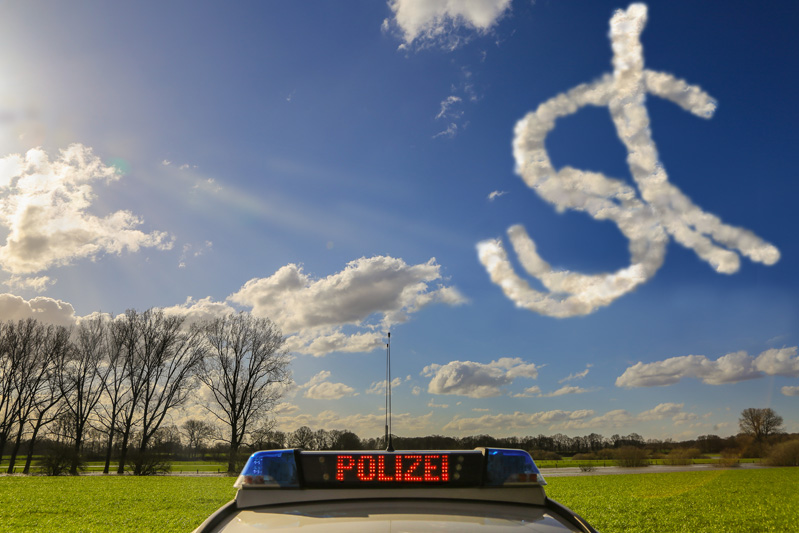 Police car with illuminated lettering "Polizei" and behind it a bright blue sky with the letters s and t drawn from clouds.