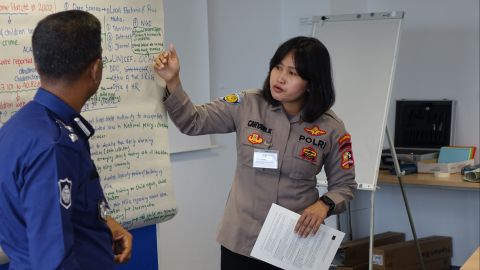 Two seminar participants stand at a whiteboard and present something.