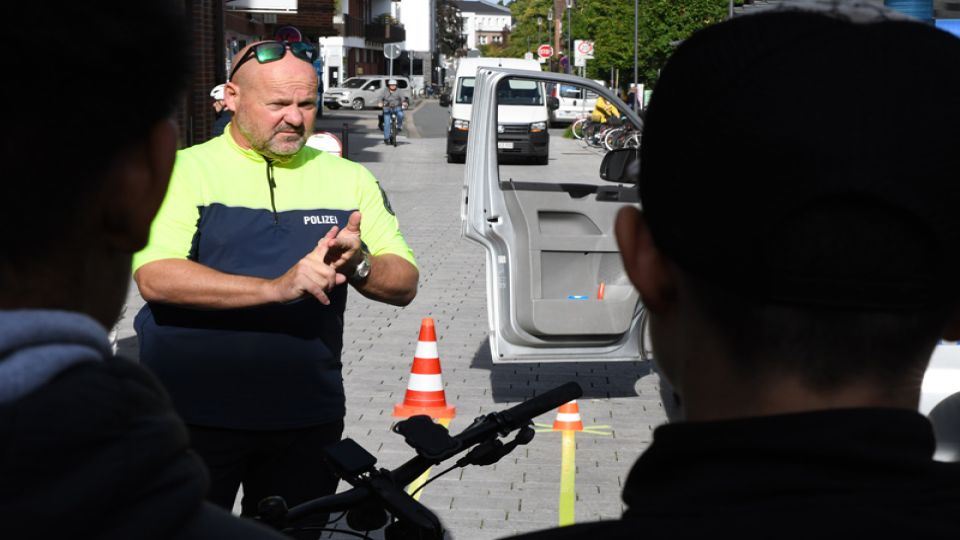 Verkehrssicherheitsberater Andreas Kröger erklärt in der Innenstadt von Rheine, wie man Dooring-Unfälle vermeiden kann. 